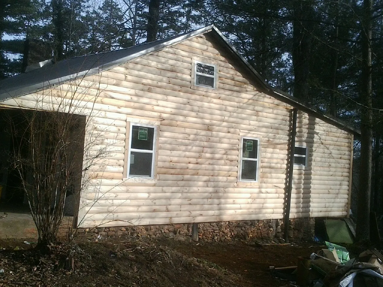 New log siding and dark metal roofing on a gable end in Dix