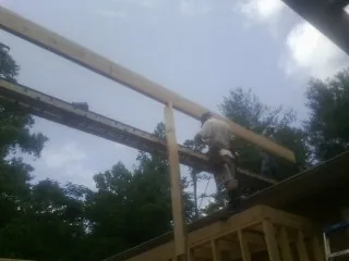 Carpenter setting a ridge beam over a new addition frame — Ice Dam Removal by Roofing Brothers in Dix