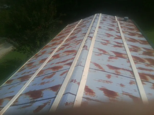 Rusted metal roof panels with new wood purlins before replacement — Storm Damage Roof Repair in Dix by Roofing Brothers