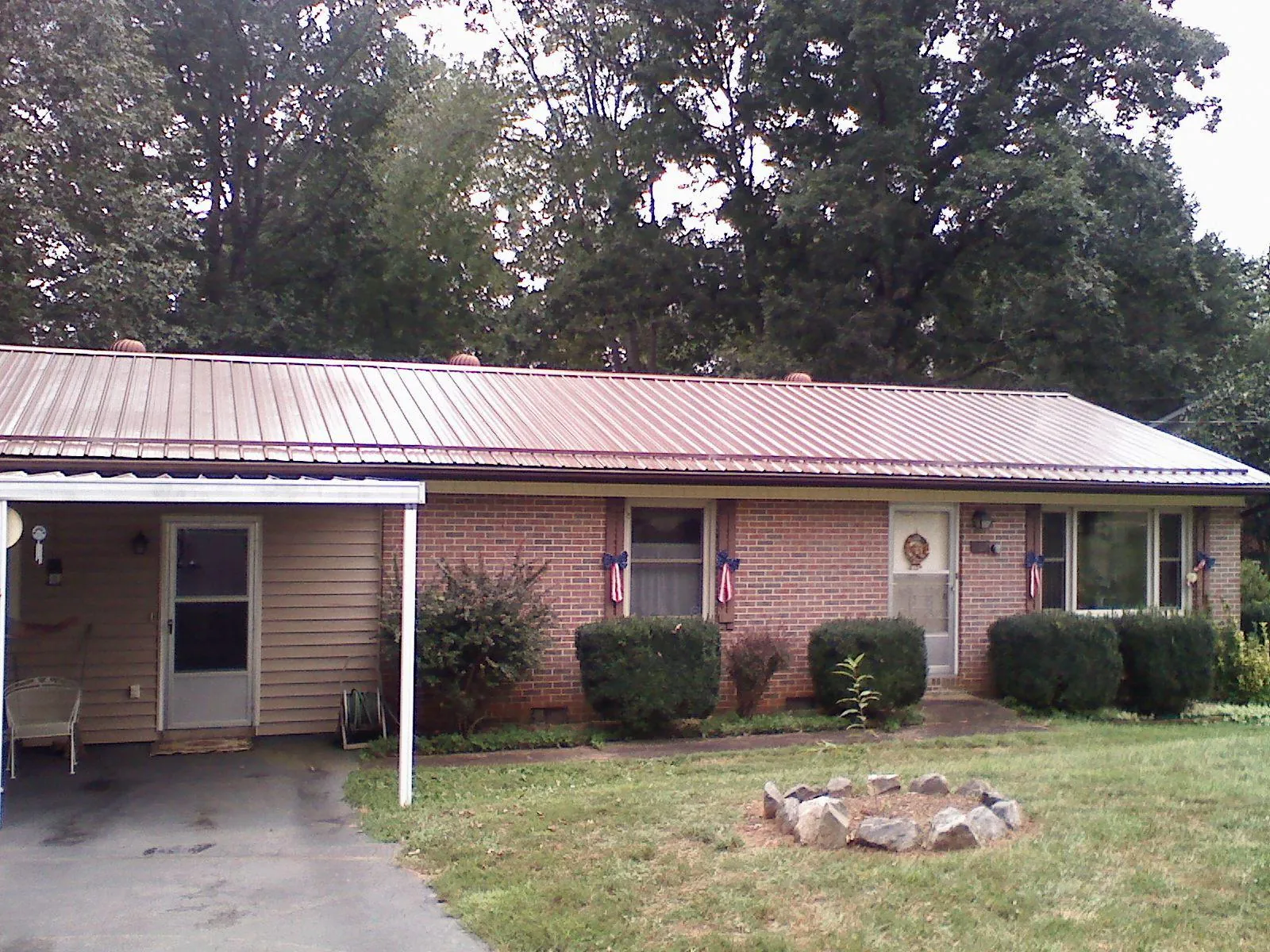 Bronze metal roof and carport on a brick ranch home — Roof Repair work by our crew in Dix